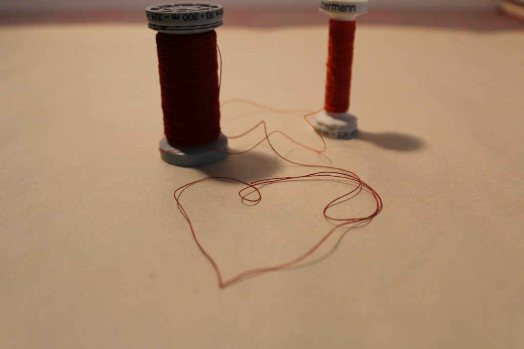Oil painting with red thread stitching